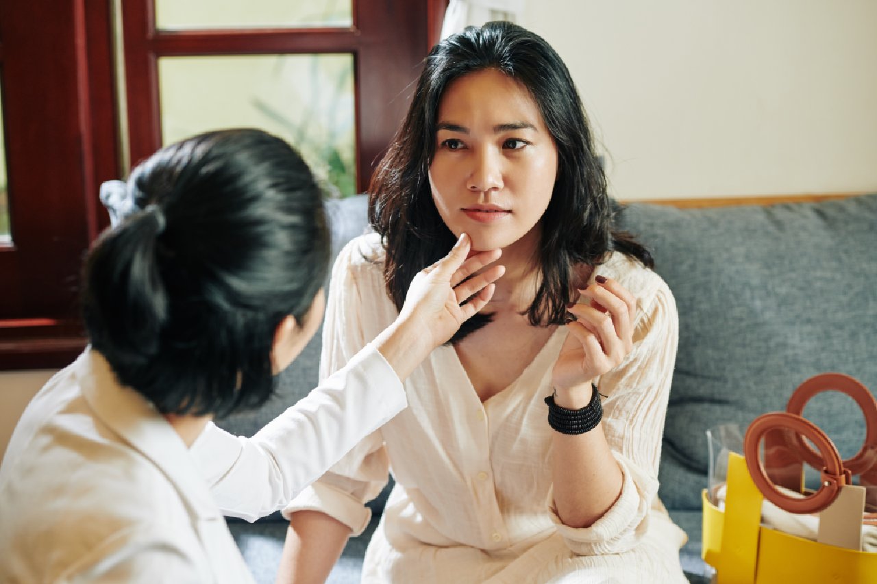 woman touching her friend's chin