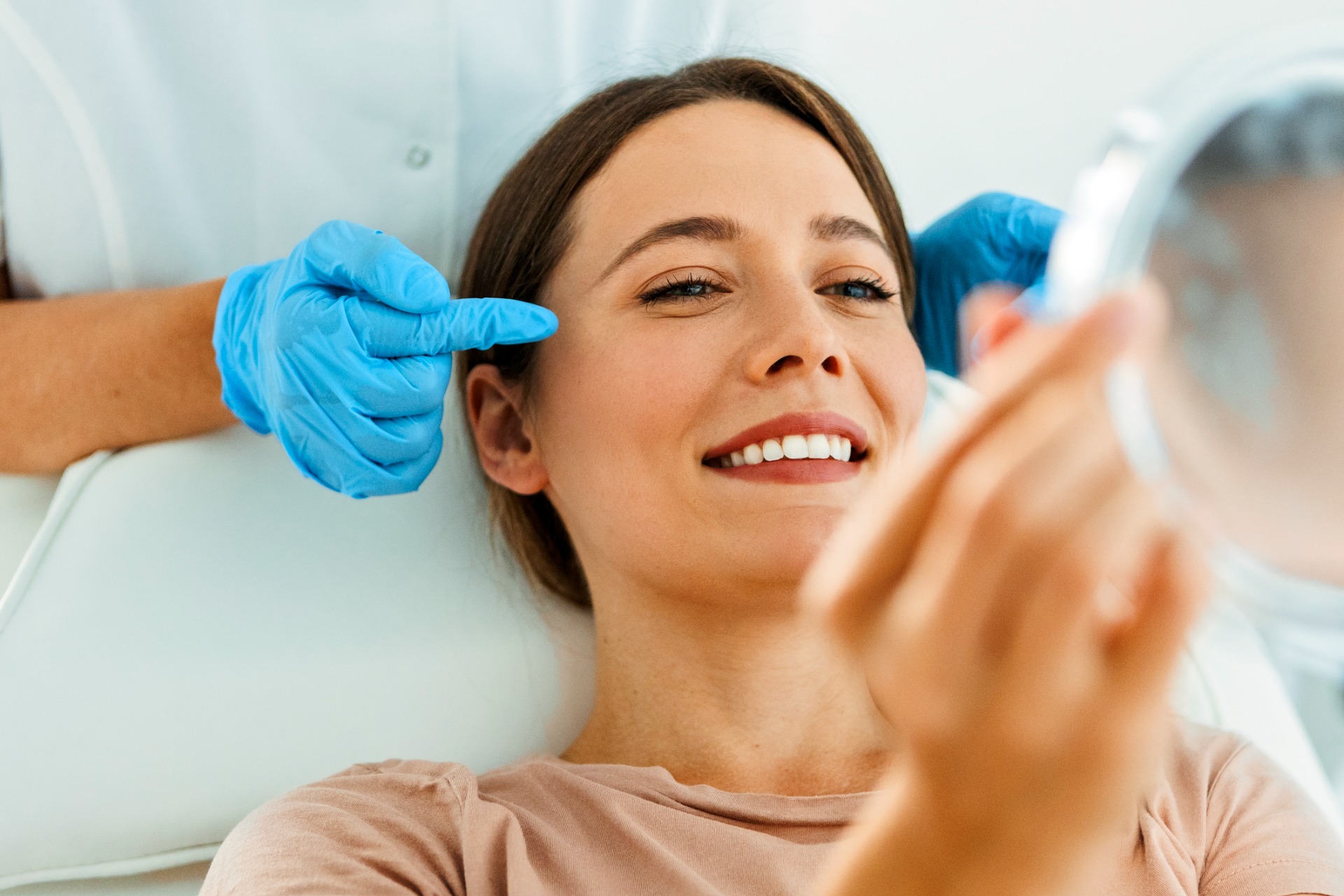 This is a photo of a woman who has just received a facelift and is admiring the results in a mirror.