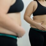 This Is A Photo Of A Woman Looking At Her Figure In A Mirror.