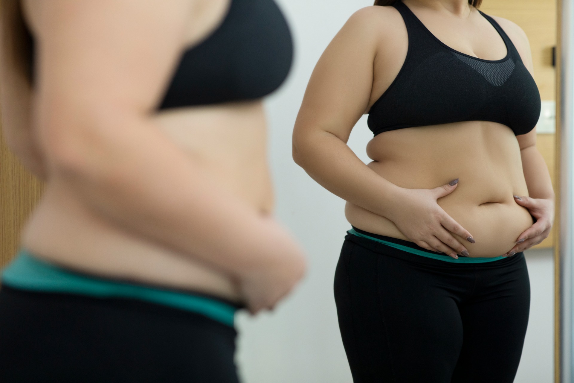 This is a photo of a woman looking at her figure in a mirror.