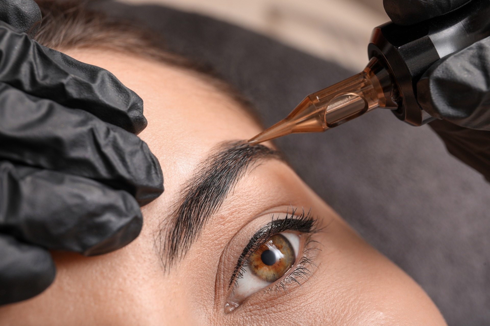 A woman undergoing an eyebrow microblading procedure